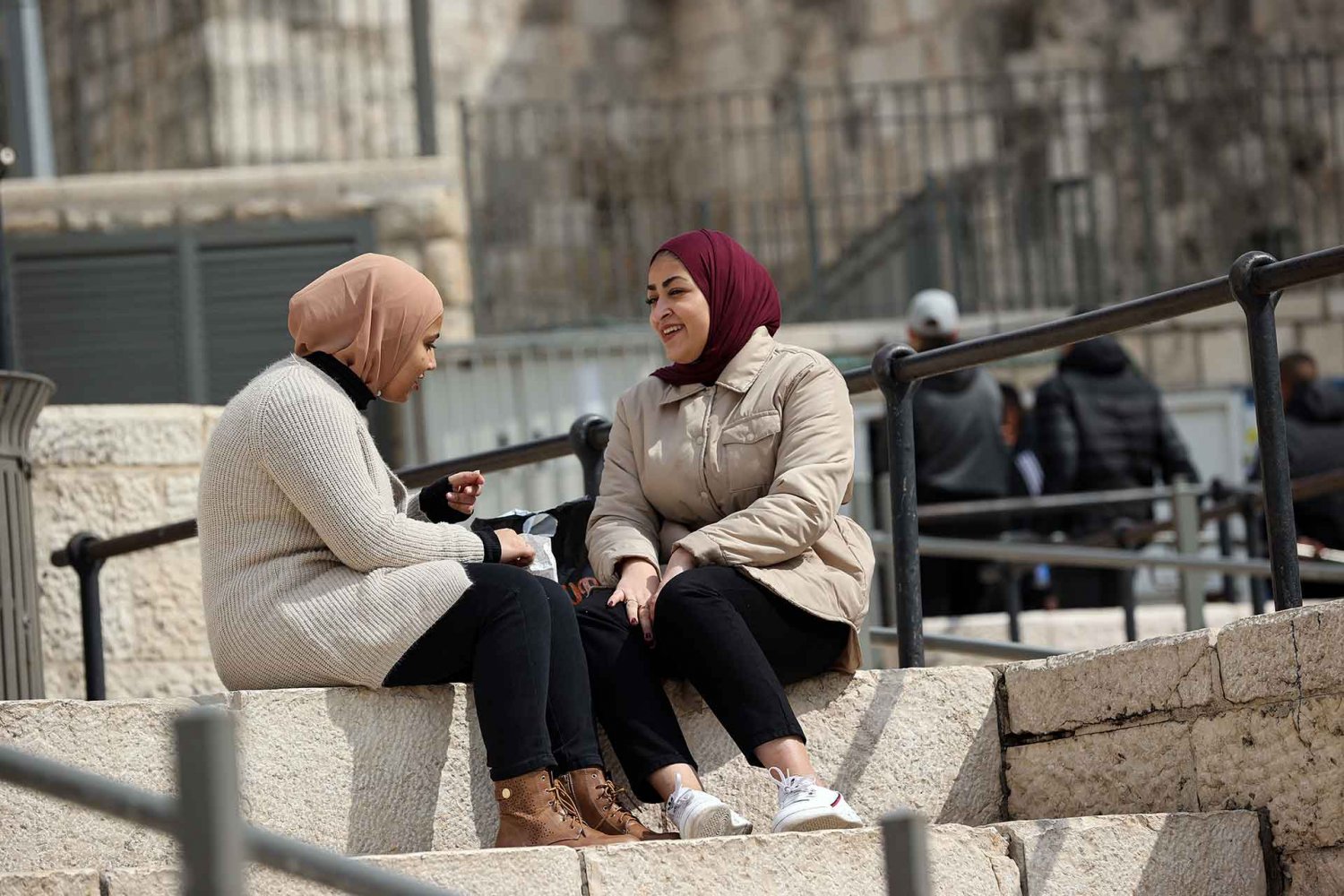 Two Palestinian women chat on the plaza steps of Damascus Gate, February 2021.