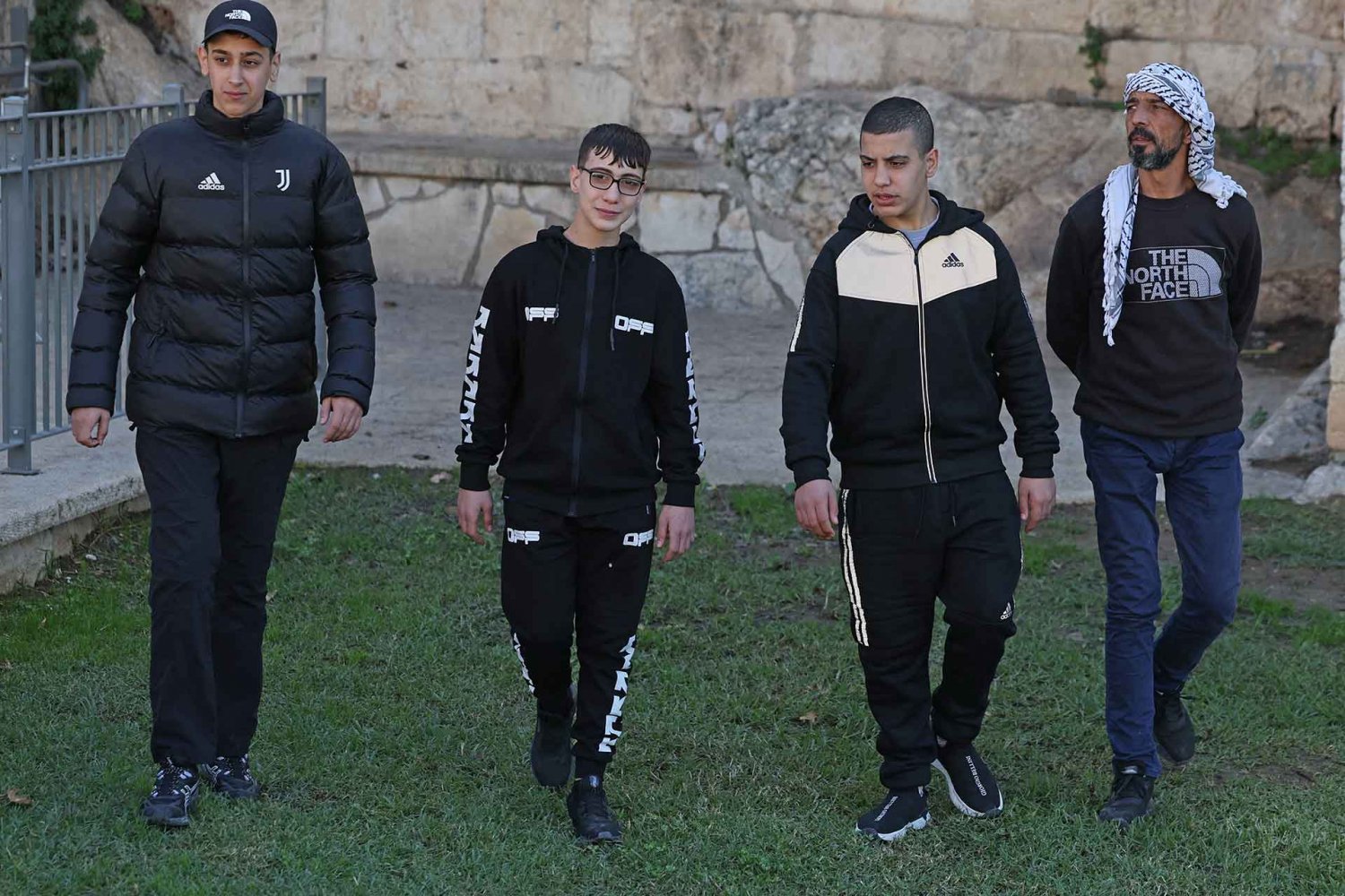 Three Palestinian Jerusalemite cousins walk together following their release in the Israel-Hamas hostage-prisoner swap, December 12, 2023.