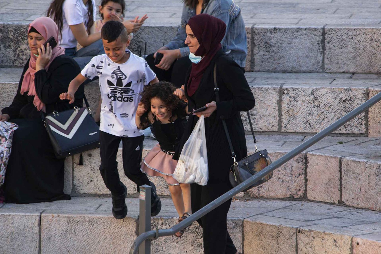 A Palestinian family joyfully descends the steps of the Damascus Gate Plaza, August 20, 2021.