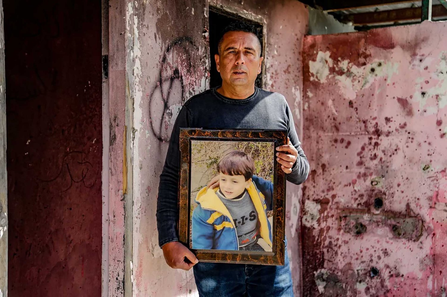 Abed Salama holds a photo of his late son, Milad.