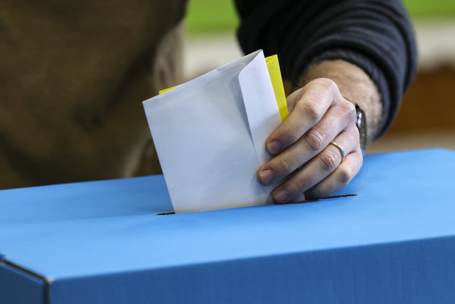 A voter drops ballots into the ballot box on election day in Jerusalem, February 27, 2024.