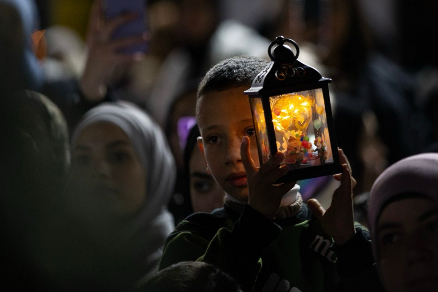 A young Palestinian boy holds a small lantern on a night of Ramadan in Jerusalem, April 2023.