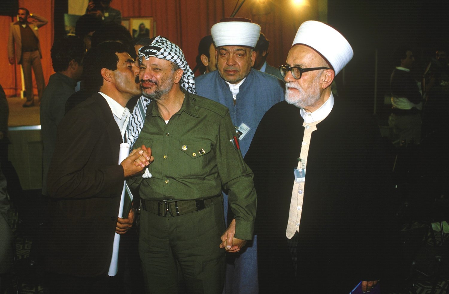 Abd al-Hamid al-Sayih and Yasser Arafat holding hands at a meeting of the PNC in Amman, Jordan, in November 1984