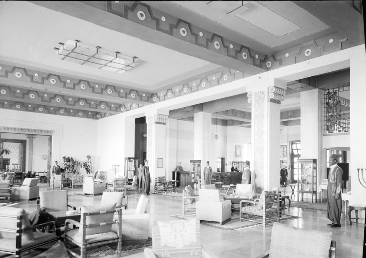 The main lounge of Jerusalem’s King David Hotel, with intimate seating and waiters standing by attentively, ca. early 1930s